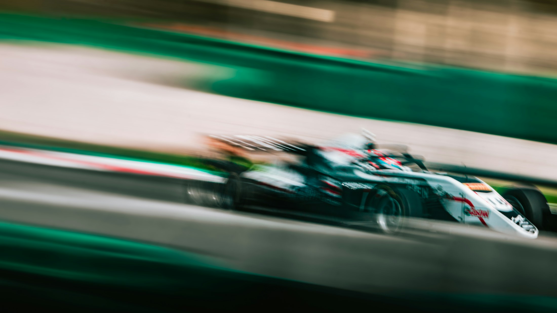 A race car blurred in motion on a circuit.