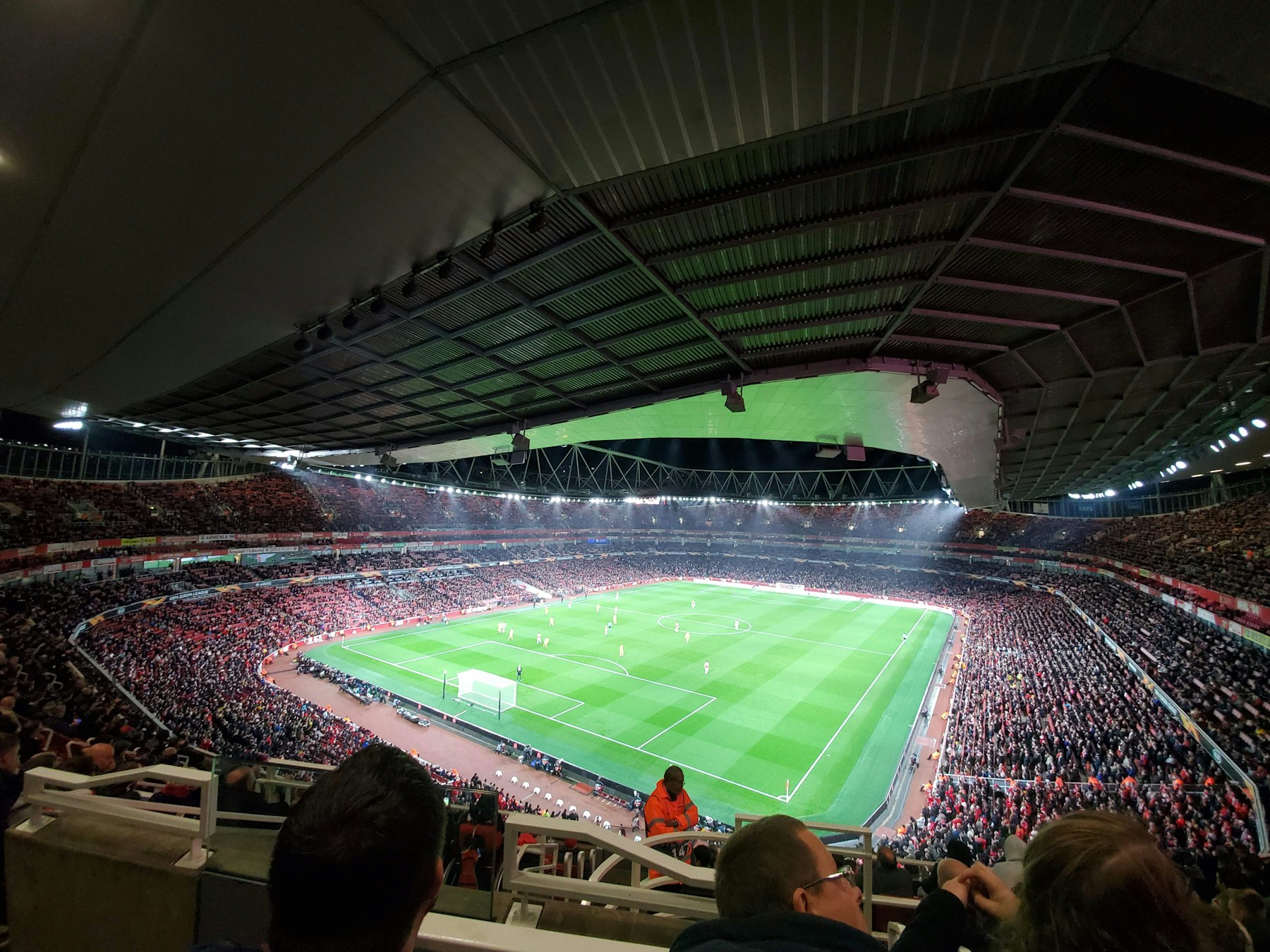 A football stadium with crowd and pitch visible.